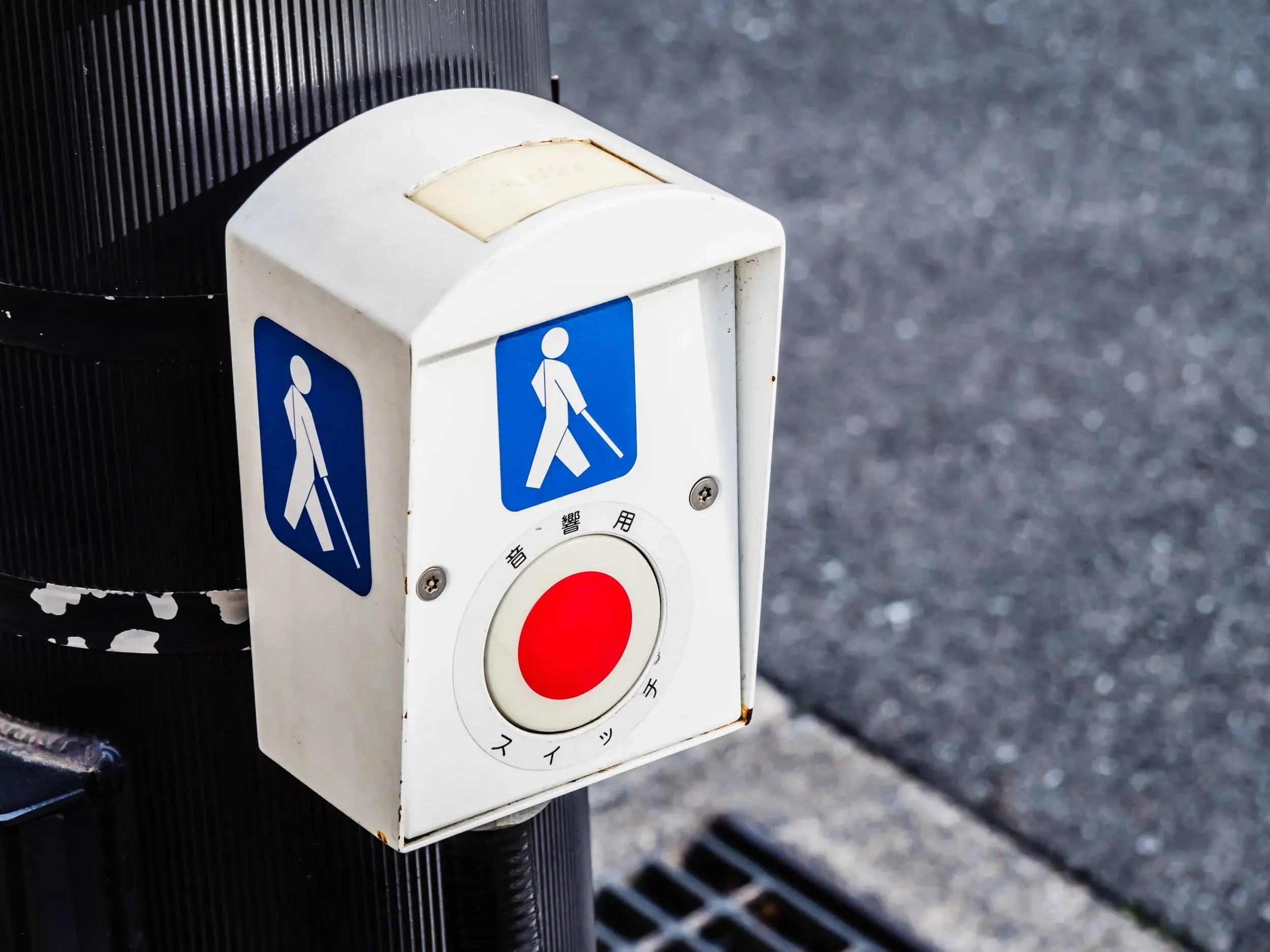 A red and white pedestrian crossing sign on a pole.